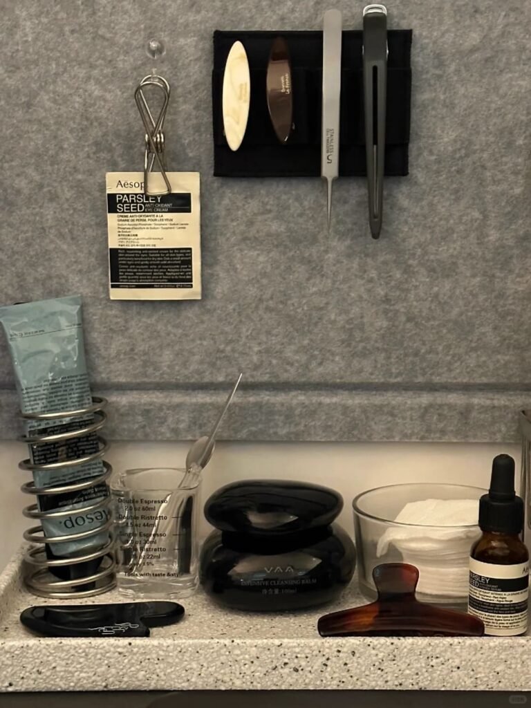 Magnetic wall strip organizing tweezers, scissors, and beauty tools in a bathroom.