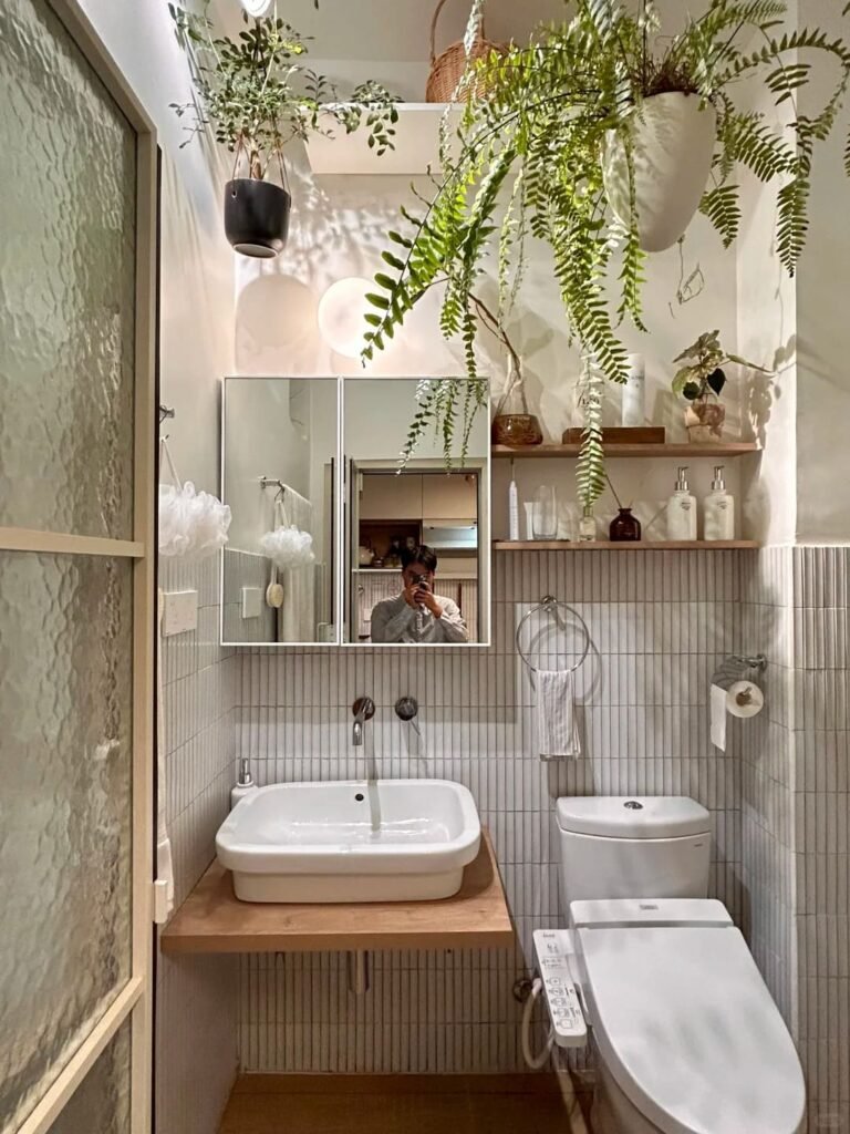 Floating wood shelf above the toilet displaying towels, baskets, and bathroom decor.