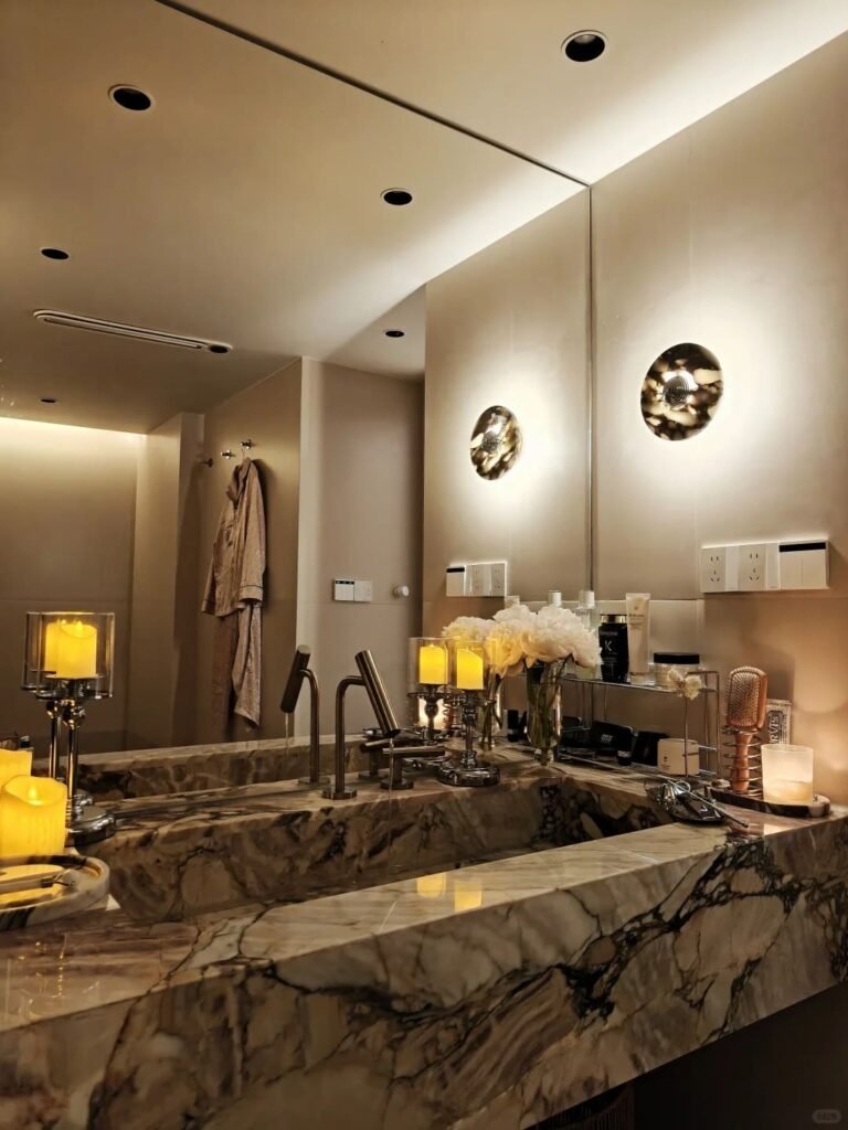 Full-wall bathroom mirror reflecting natural light to make a small bathroom feel larger.