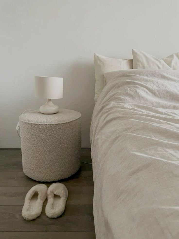 A cozy cream-colored bouclé-textured nightstand with a soft, nubby fabric finish and rounded corners.