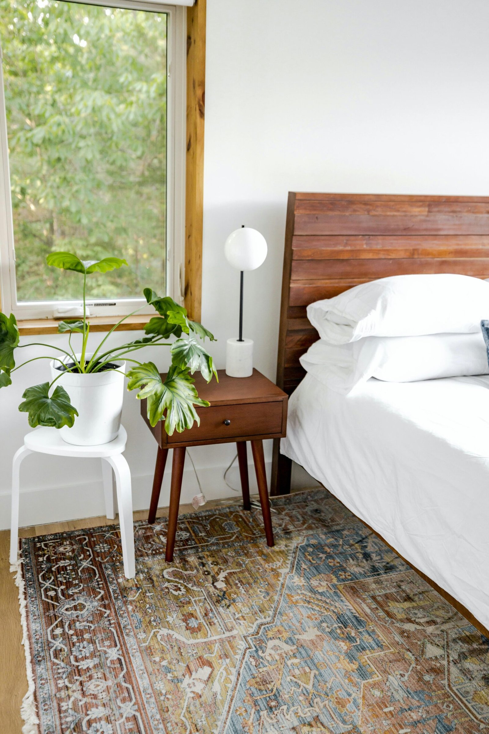 Aesthetic 2026 bedroom with a white cloud bed anchored by a large cream plush rug on light oak floors.