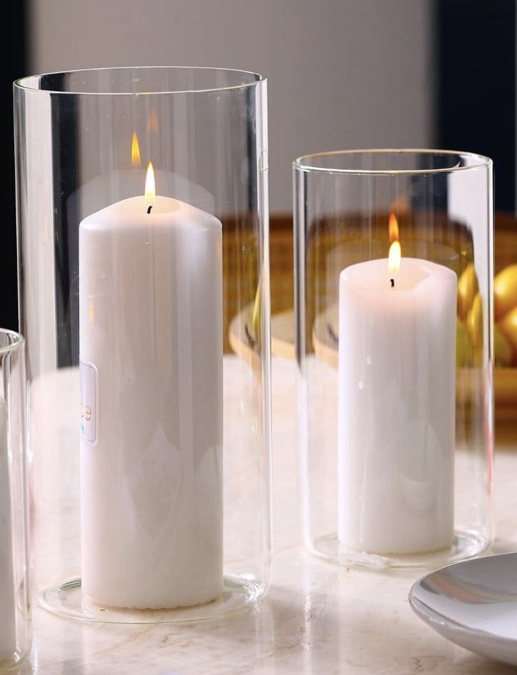 Sculptural candle in a ceramic vessel with natural wax pools, placed on a marble countertop to emphasize reusable container design