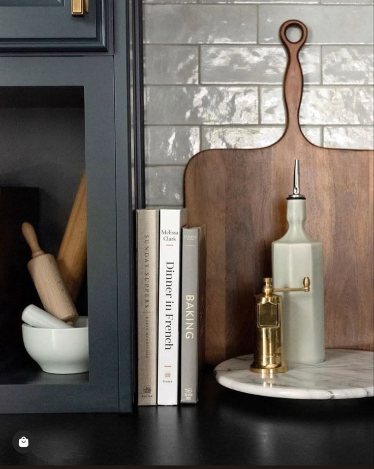 Singular stack of three neutral cookbooks tied with leather strap as quiet kitchen counter decor
