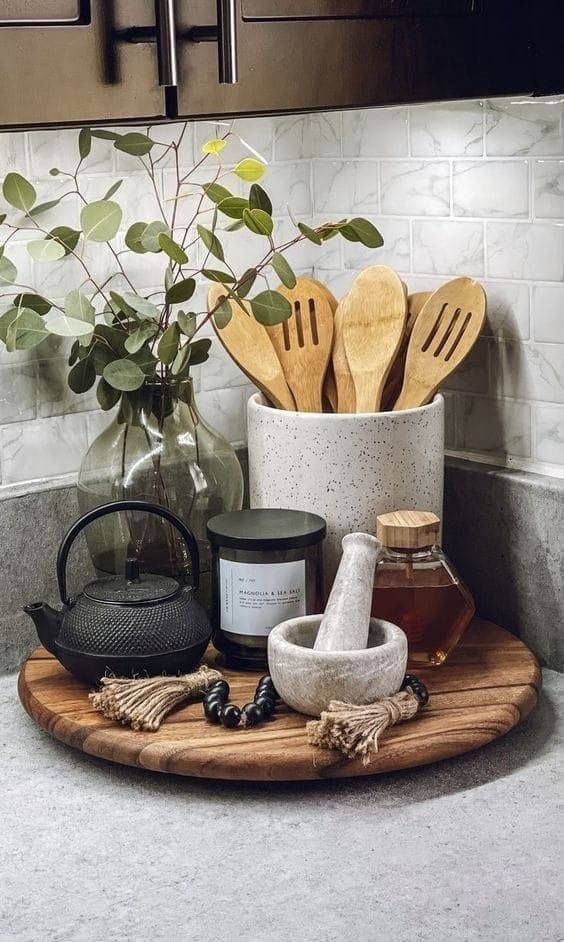 Sculptural ceramic utensil crock holding wooden spoons