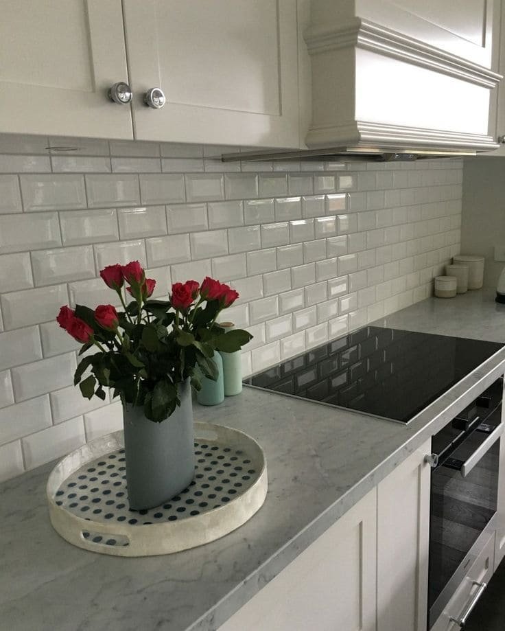 Beveled ceramic tile in cream with subtle shadow lines, a timeless kitchen backsplash idea