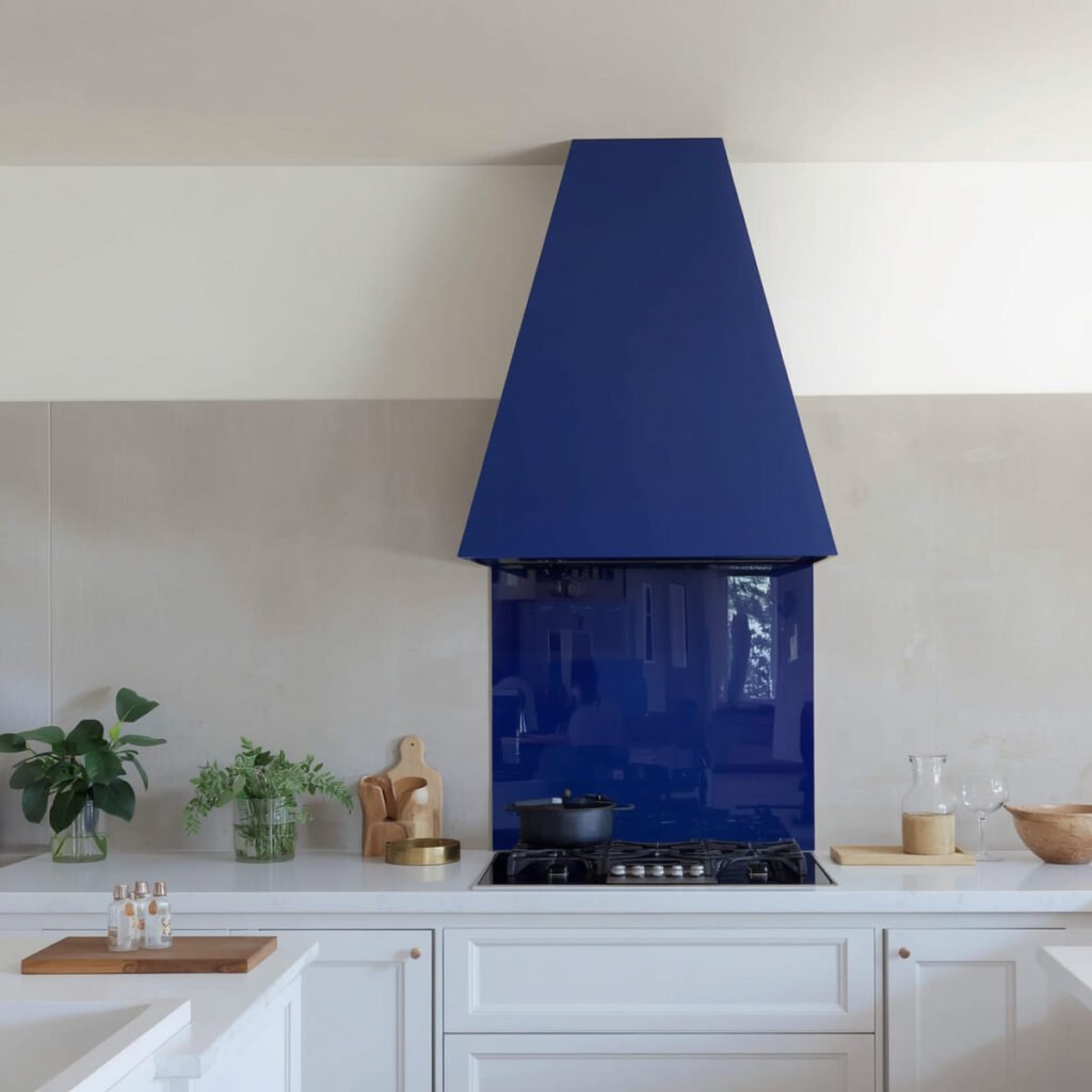 Striking chimney range hood as the focal point, surrounded by neutral white perimeter cabinets