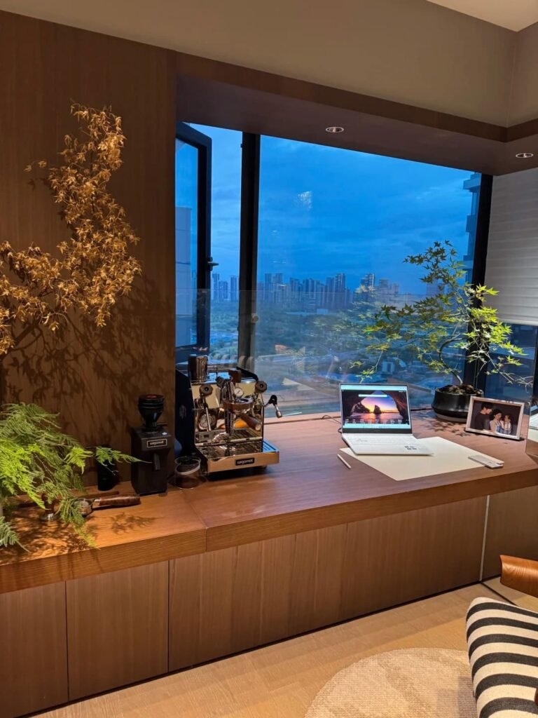 Simple home office decorated with a tall sculptural branch displayed in a ceramic vase.
