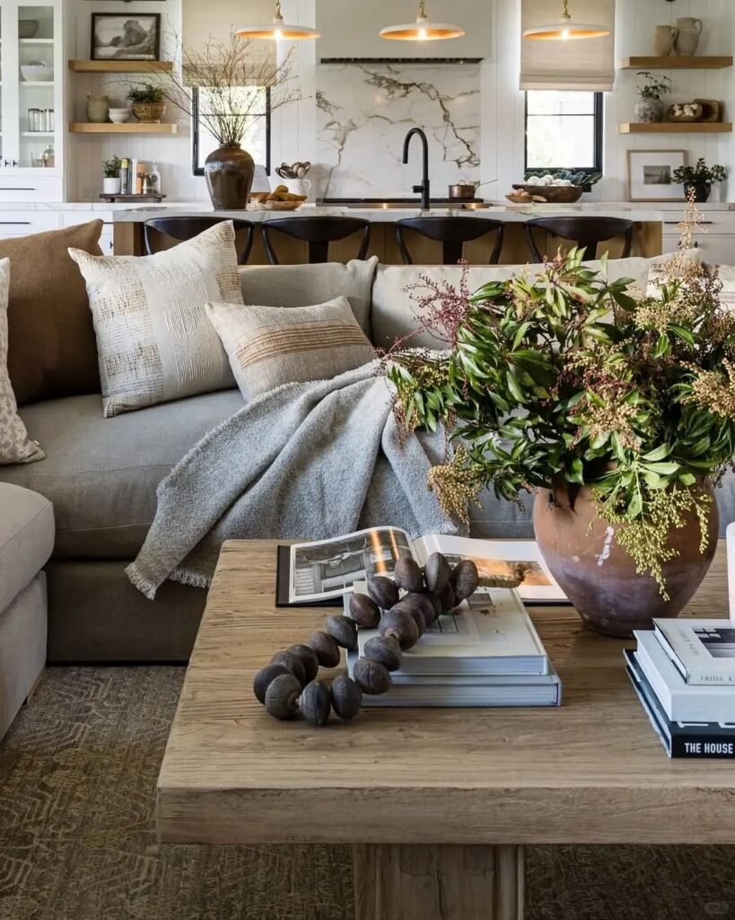 Coffee table decorated with stacked coffee table books topped with a ceramic vase and decorative object.
